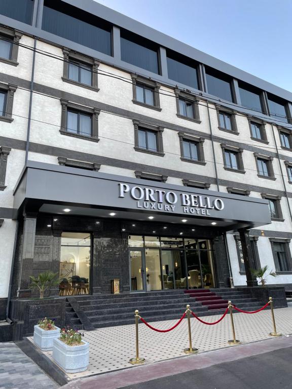 uma vista frontal de um hotel com uma placa em Porto Bello Hotel em Tashkent