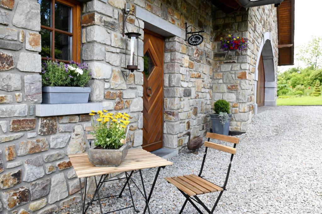 een tafel en twee stoelen voor een stenen gebouw bij Loft-Style-Living Schütt - einfach anders in Monschau