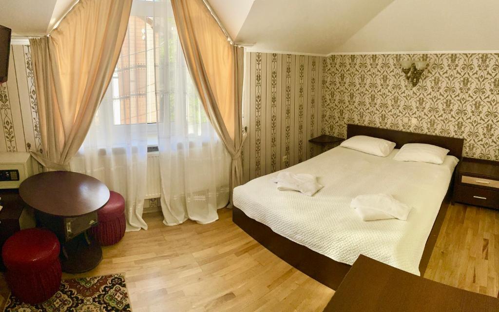 a bedroom with a large bed and a window at Near the Lake in Lviv
