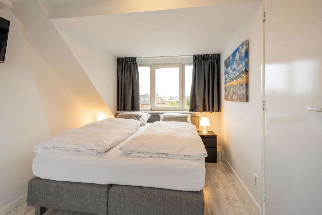 um quarto com uma cama e uma janela em The Palmtree em Zandvoort