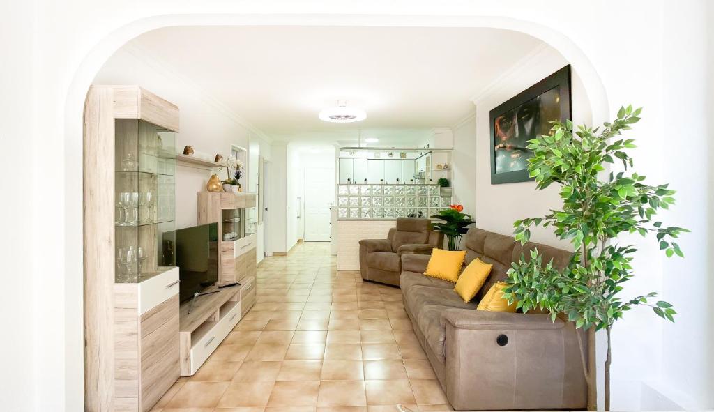 a living room with a couch and a tv at KORALLIA GUESTHOUSE Castle Harbour in Los Cristianos