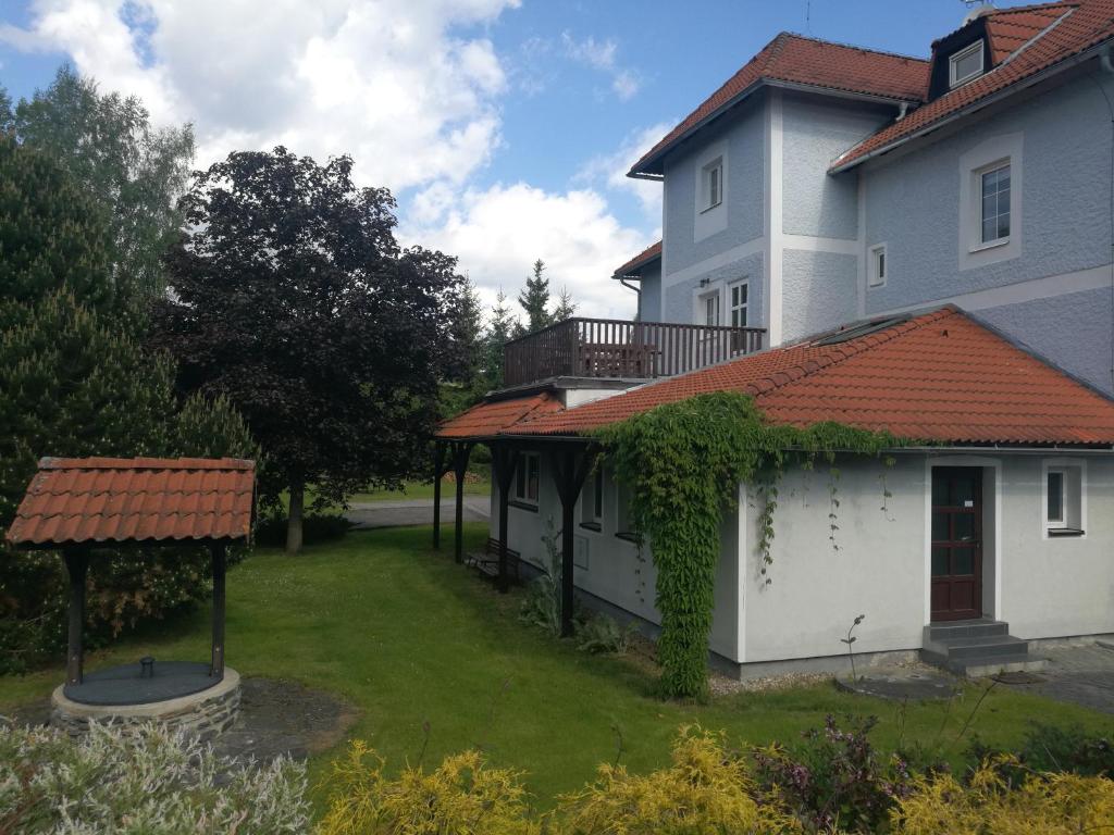 une maison blanche avec un toit rouge et une cour dans l'établissement Lipno - Hůrka, Marcela Appartements, à Horní Planá