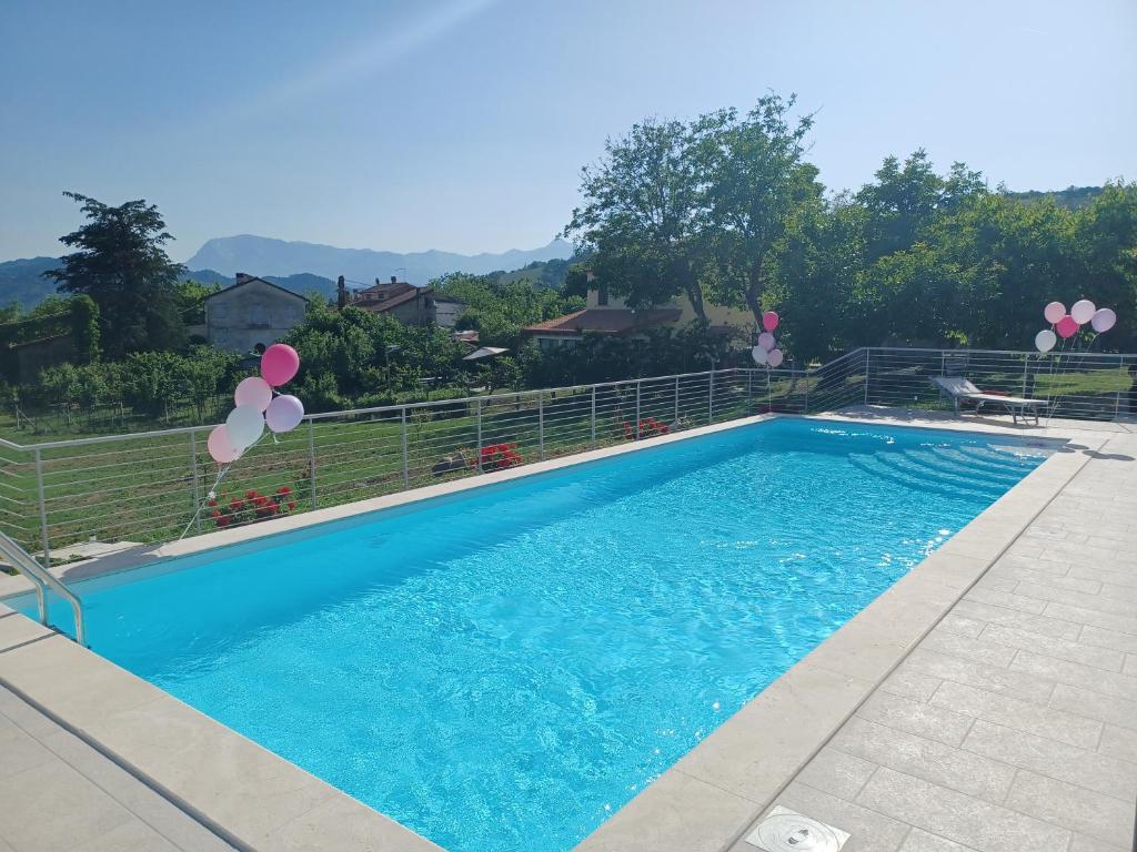 una grande piscina blu con palloncini in un cortile di Le Margherite Country House a Montefalcone Appennino