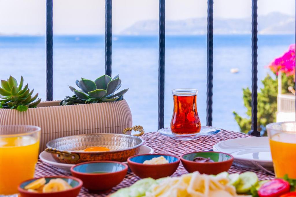 a table with plates of food and a glass of orange juice at Kaş Old Town Hotel in Kaş
