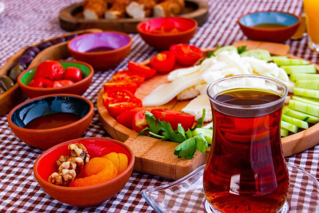 a table topped with bowls of vegetables and a drink at Kaş Old Town Hotel in Kaş