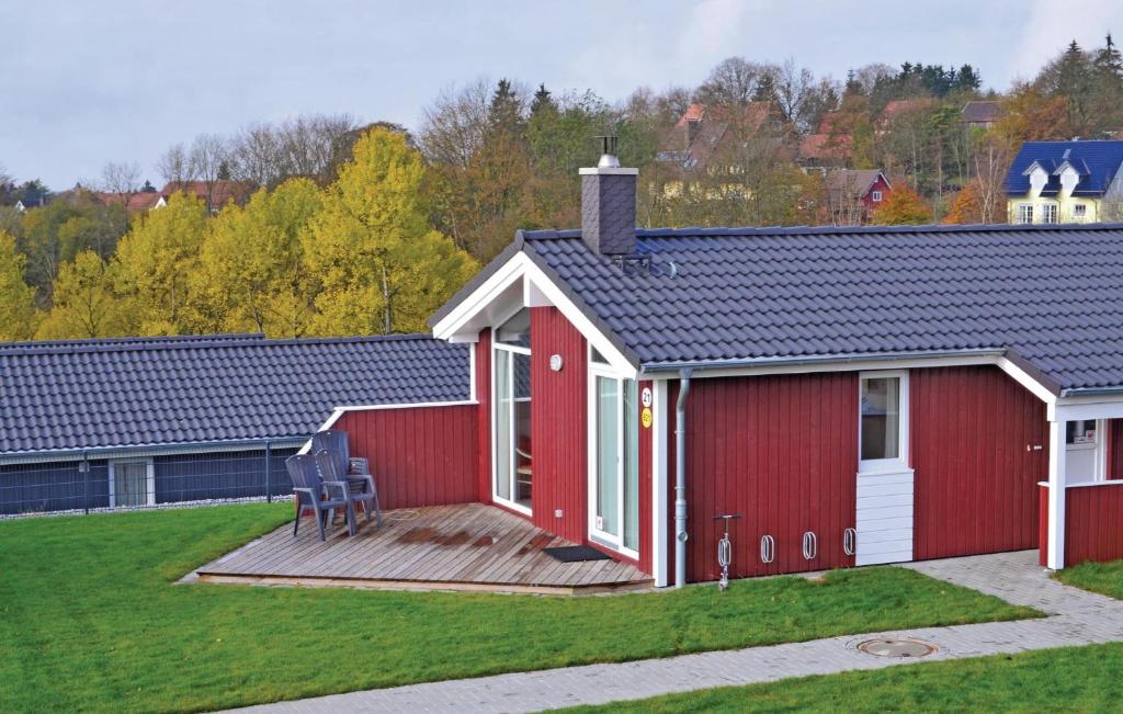 ein rotes Gebäude mit einer Terrasse im Hof in der Unterkunft Ferienhaus Venus B in Sankt Andreasberg