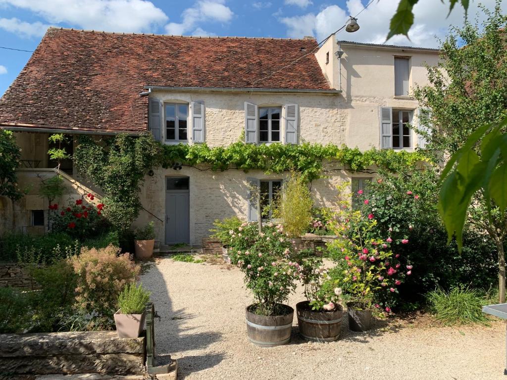 un cottage avec des fleurs devant lui dans l'établissement La Ferme de Victor - Maison de village, à Coussegrey