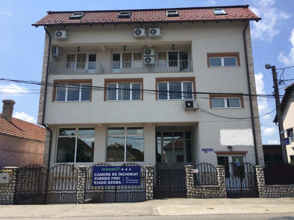 a building with a sign in front of it at Cazare Hofmann in Arad