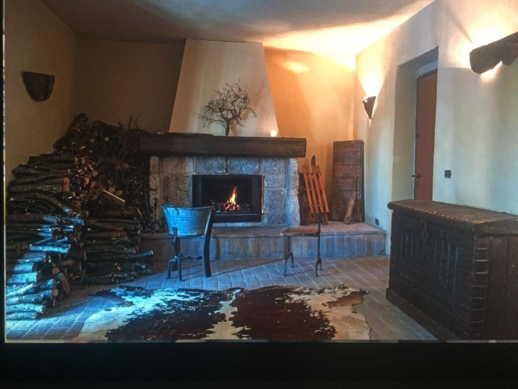 a living room with a fireplace and a table and chairs at La pietra in Roccamorice
