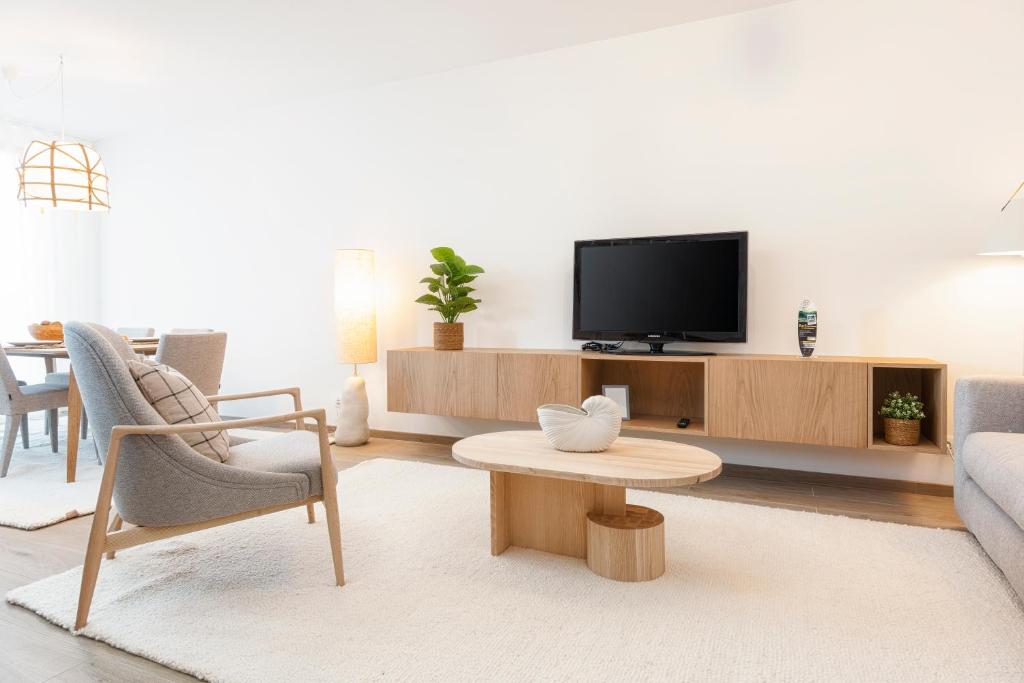 a living room with a tv and a couch and a table at CATCH - Vilamoura in Vilamoura