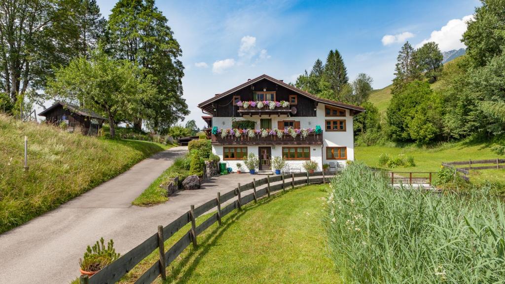 a house on a hill with a path in front at Haus am Teich - Fewo Relax mit Bergbahn Unlimited in Oberstdorf
