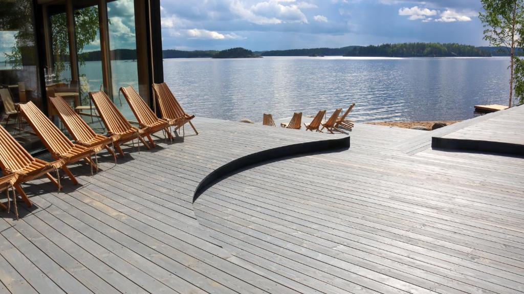 un grupo de sillas sentadas en una terraza junto al agua en Pistohiekka Resort, en Puumala