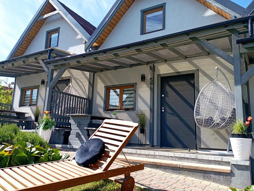 a house with a bench in front of it at Domki U Wojtka w Niechorzu in Niechorze