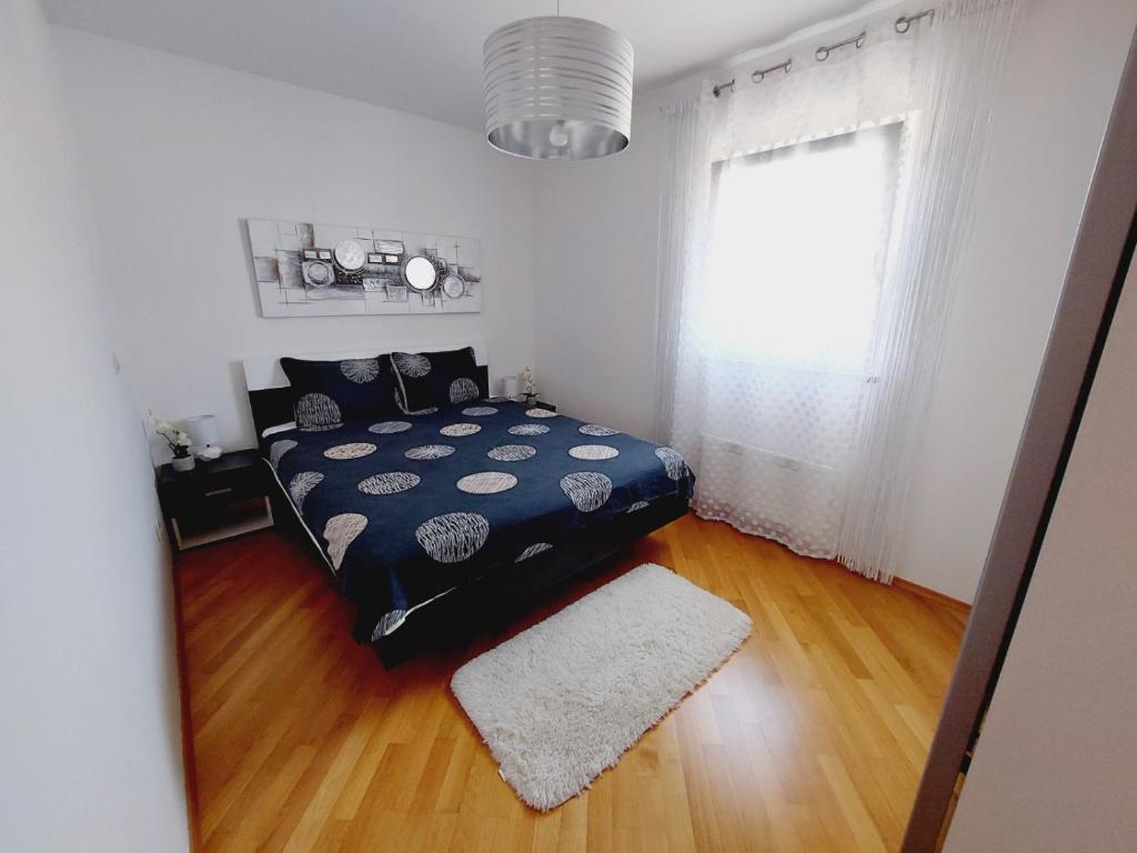 a bedroom with a bed and a window at Apartment Rose in Malinska