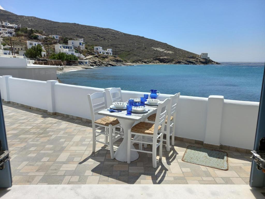 uma mesa branca e cadeiras numa varanda com vista para o oceano em Anthie's shore house em Istérnia