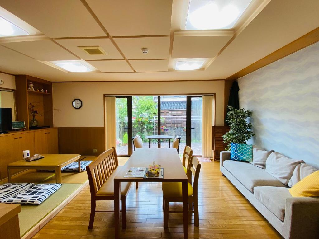 uma sala de estar com uma mesa e um sofá em のと海 em Nanao