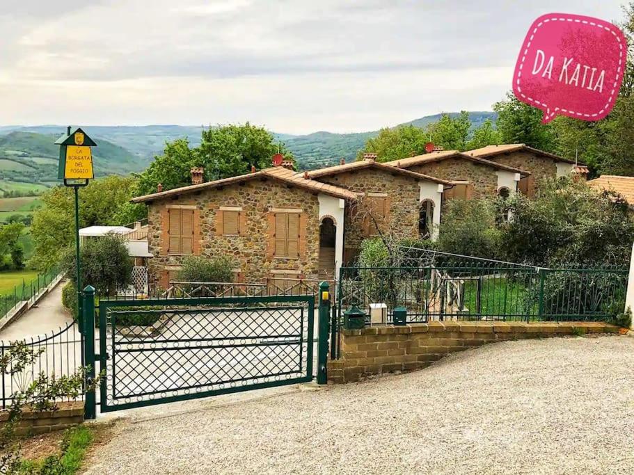 um portão em frente a uma casa com um sinal em Il Poggio da Katia em Saturnia