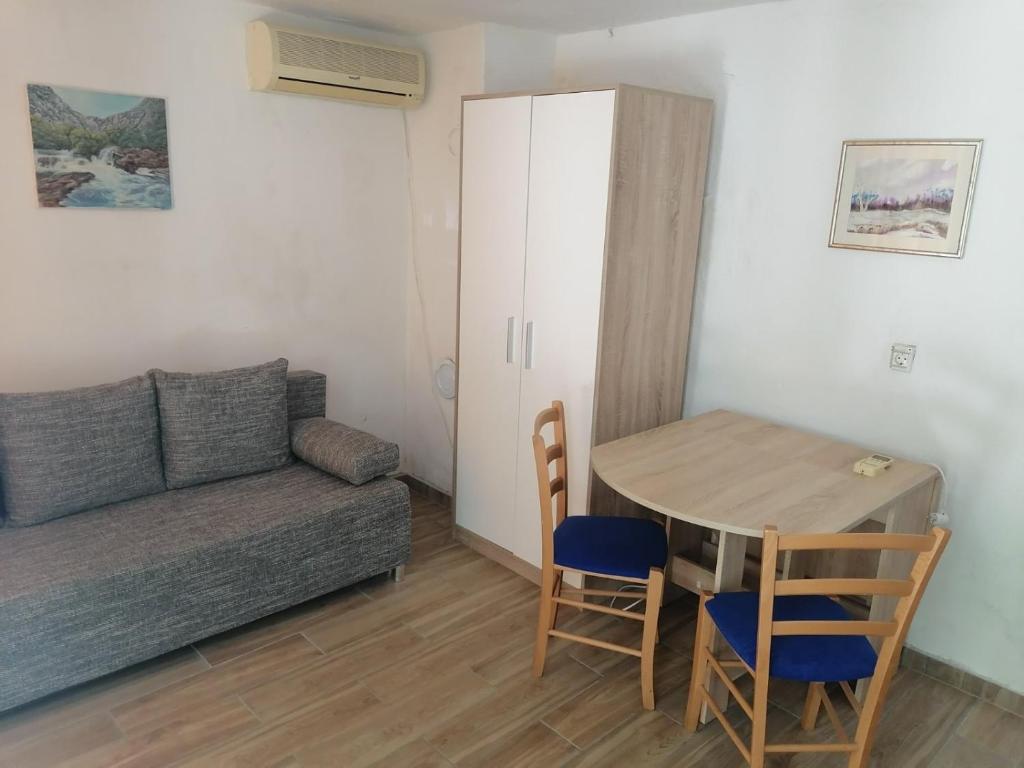 uma sala de estar com um sofá e uma mesa em Apartman Milica em Golubić