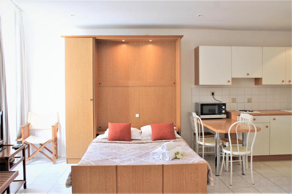 a bedroom with a bed and a kitchen with a table at Viva Riviera 6 Rue Commandant André in Cannes