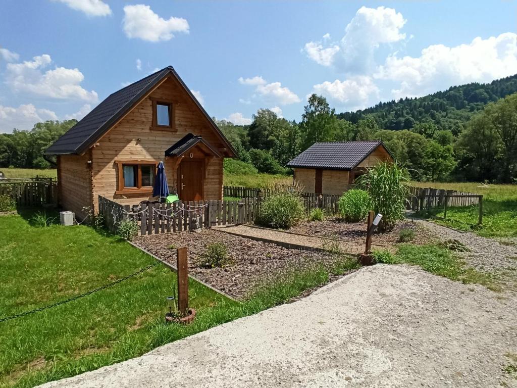 eine Blockhütte auf einem Feld mit Garten in der Unterkunft Dolina Rosy in Ustrzyki Dolne