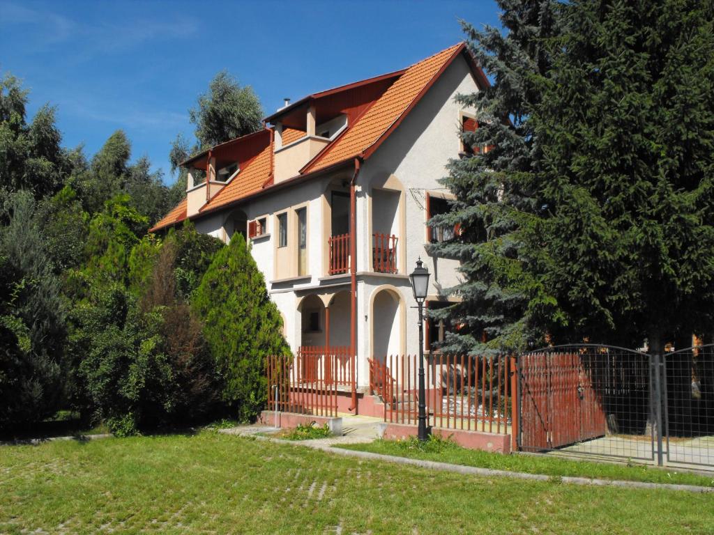 a house with an orange roof and a fence at Ágnes Pihenőház in Szilvásvárad