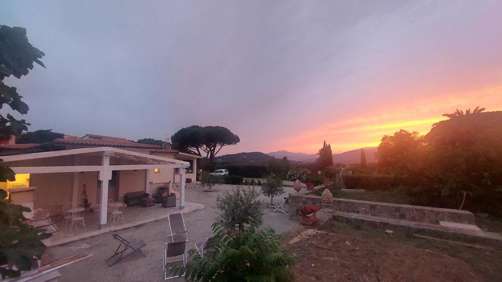 a view of a house with a sunset in the background at Podere Grandolfi B&B in Capoliveri