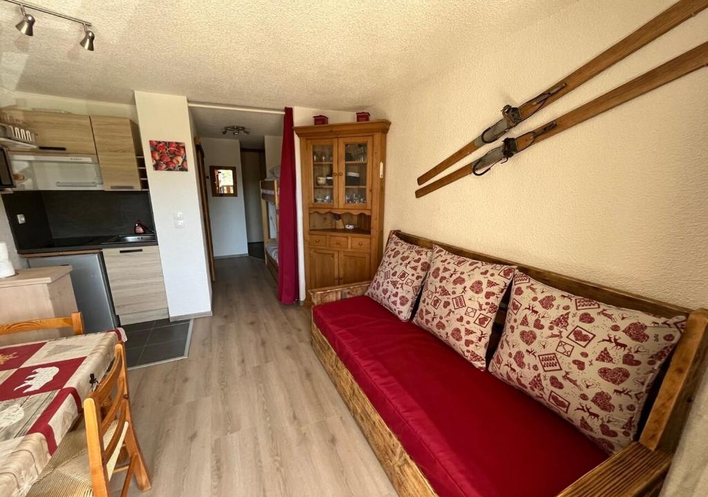 uma sala de estar com um sofá vermelho num quarto em Grand Studio em Les Carroz d'Arâches