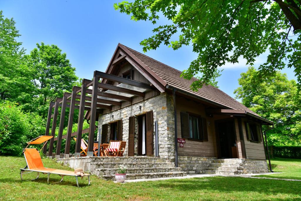 una pequeña casa de piedra con techo en Villa Dobra, en Lagos de Plitvice