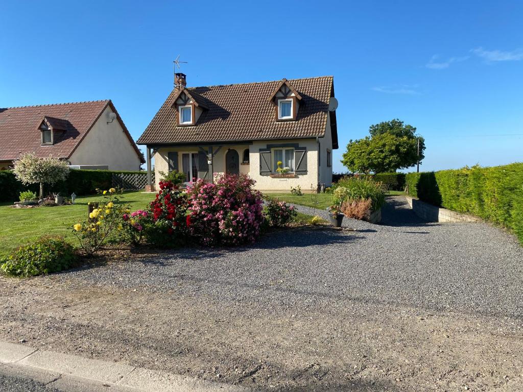 a house with a lot of flowers in the driveway at La clé des champs in Acheux-en-Vimeu