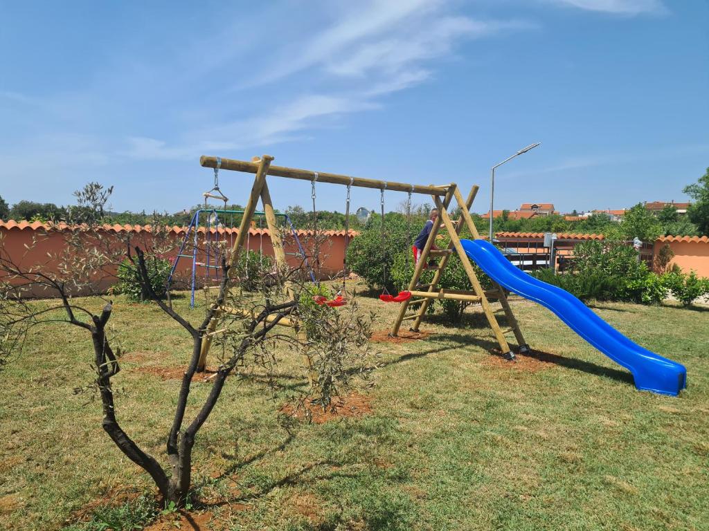 a playground with a blue slide in a yard at Romantic Villa Sejdić in Pula