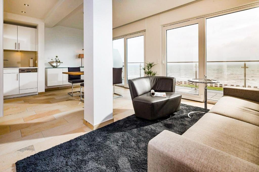 un soggiorno con un divano e una sedia di Penthaus 14 Strandvilla Therese a Norderney