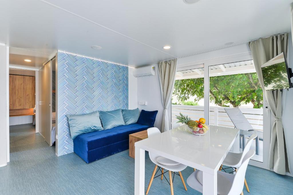 圖納的住宿－Adria Nova kamp Laguna，客厅配有蓝色的沙发和桌子