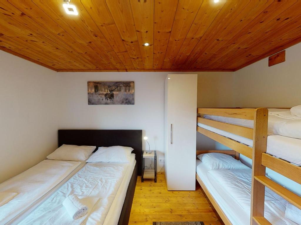 2 Etagenbetten in einem Zimmer mit Holzdecken in der Unterkunft Chalet Fürth - by Four Seasons Apartments in Piesendorf