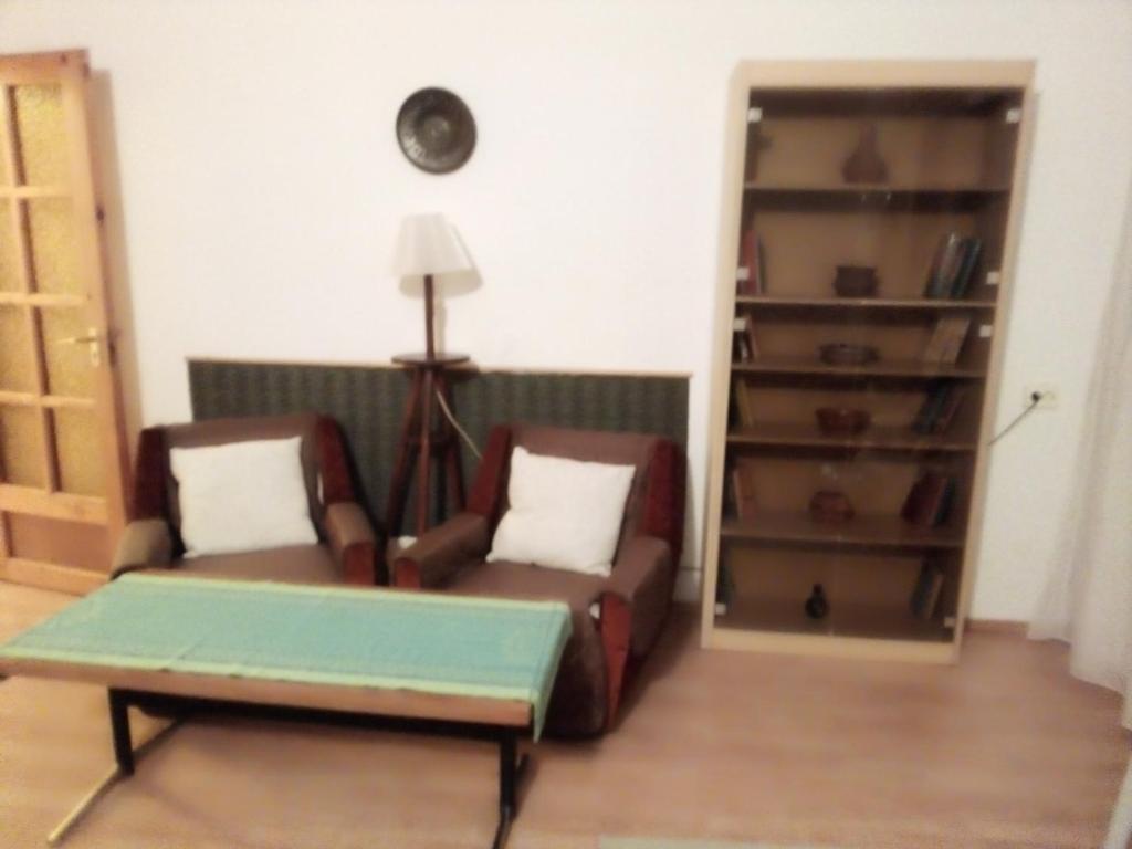 salon z 2 krzesłami i stołem w obiekcie Panoráma Pihenőház w mieście Balatonalmádi