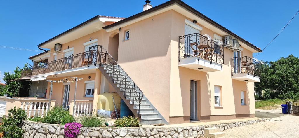 une grande maison avec un escalier en face de celle-ci dans l'établissement Apartments Pinezić, à Skrbčići