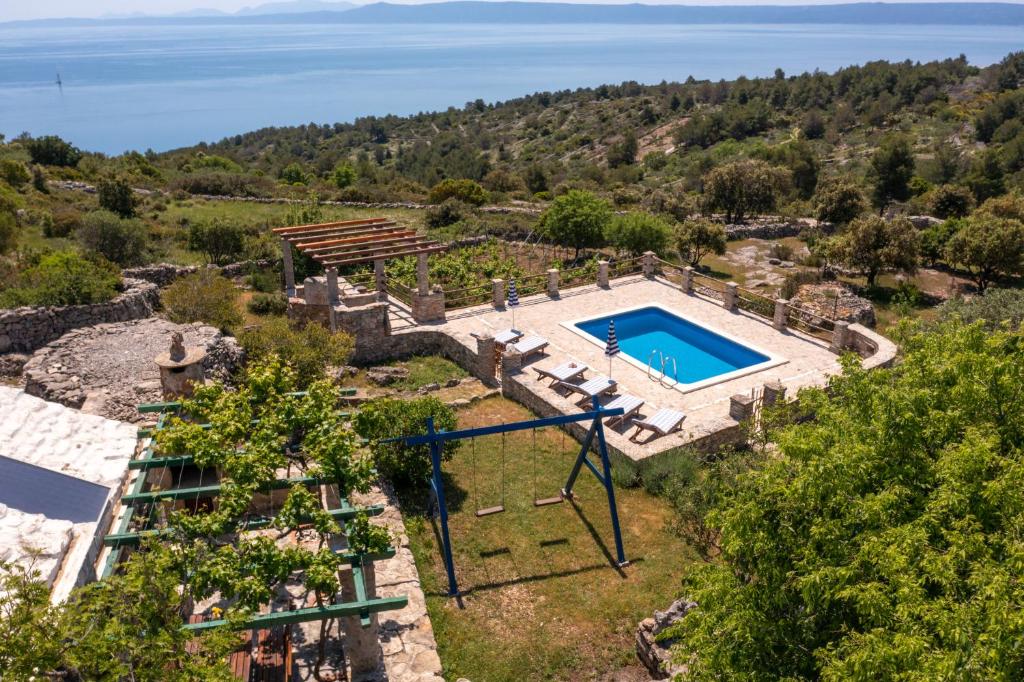 einen Luftblick auf eine Villa mit einem Pool in der Unterkunft The Ultimate Escape - two traditional cottages & private pool in Selca