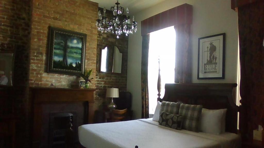 a bedroom with a large bed and a large mirror at Lafitte Hotel & Bar in New Orleans