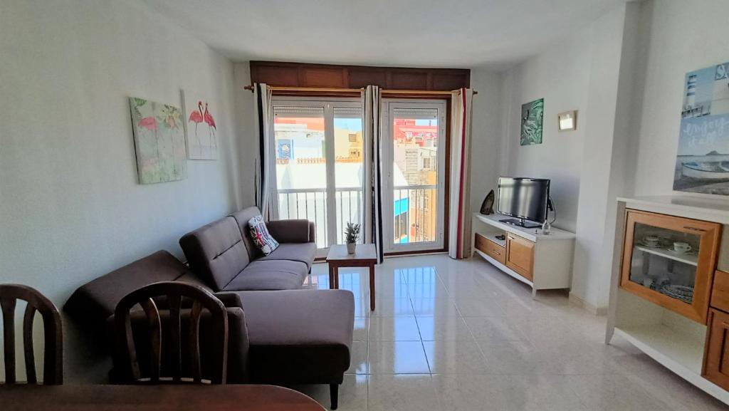 sala de estar con sofá y TV en alquilaencanarias Tio Claudio Beach, en El Médano