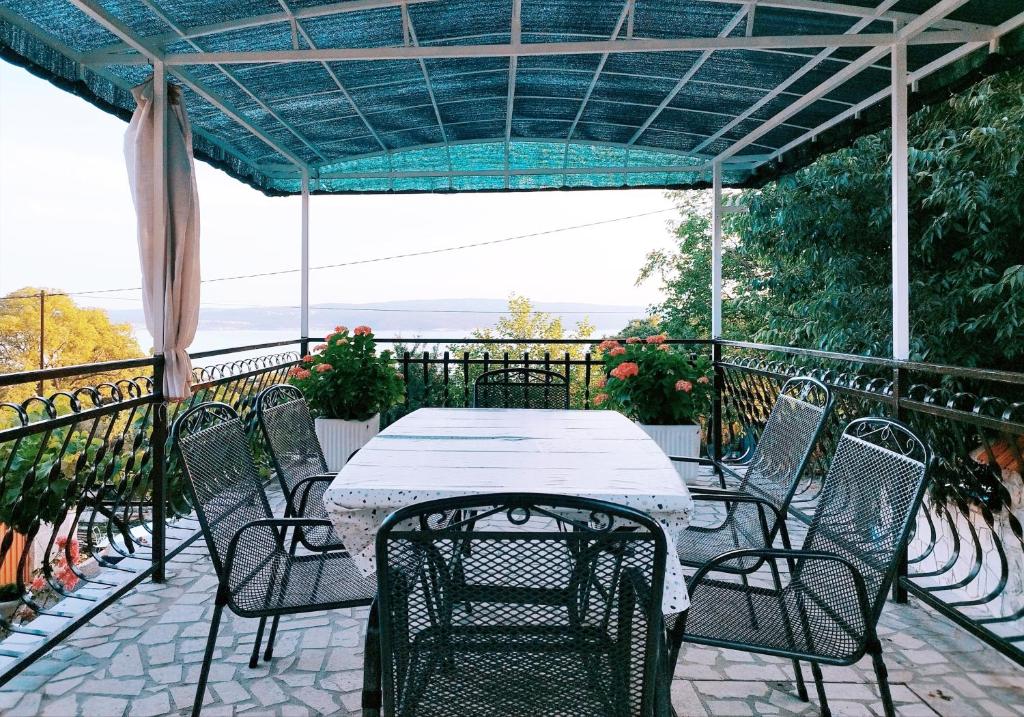 a table and chairs on a balcony with a blue canopy at Apartment Ane in Dramalj
