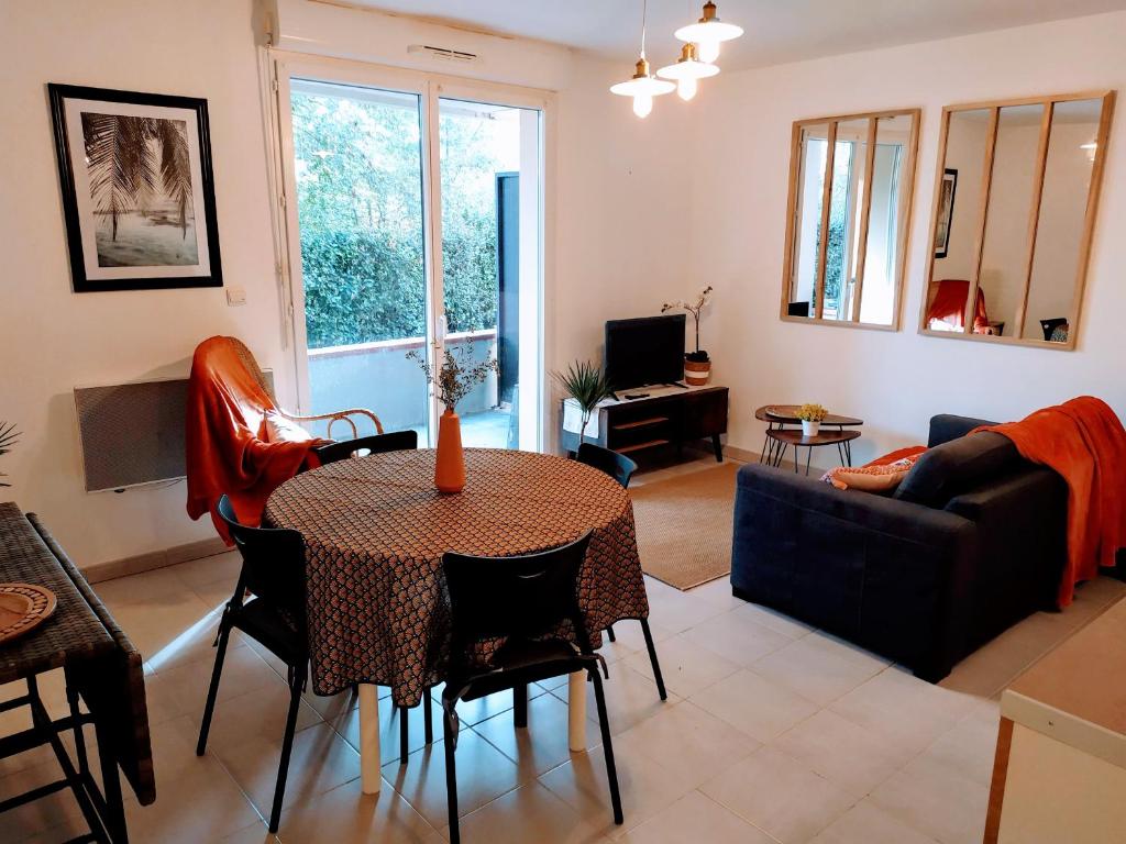 ein Wohnzimmer mit einem Tisch und einem Sofa in der Unterkunft Petit chemin des Flouries in Gaillac