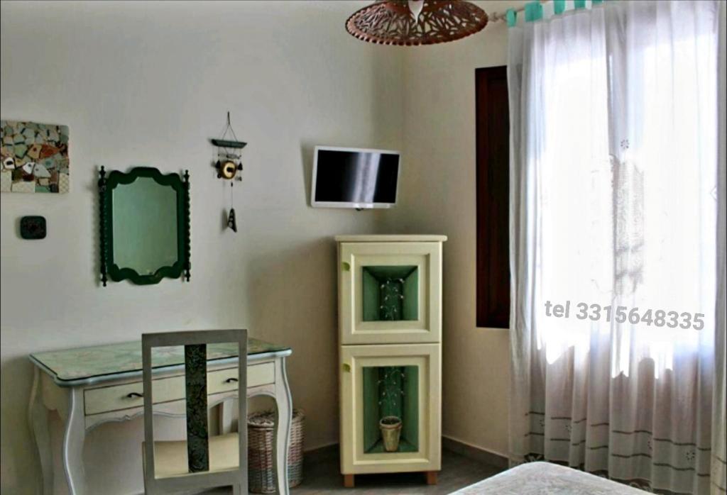 una camera con tavolo e TV a parete di Azzurromare a San Vito lo Capo