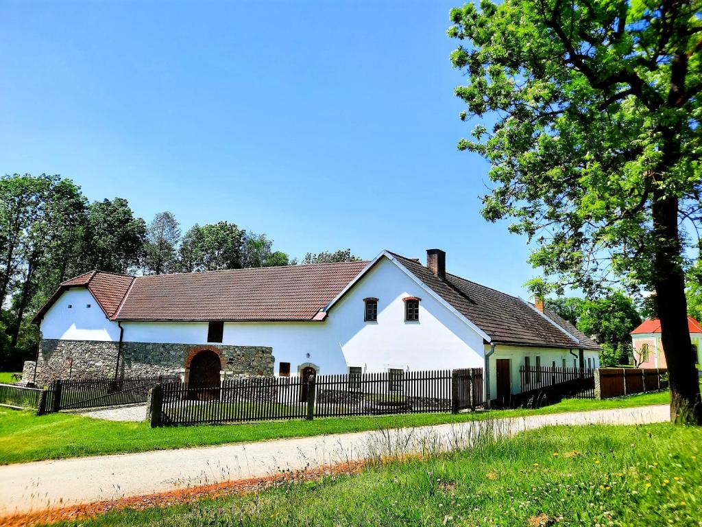 a white house with a fence around it at Statek Ctiboř in Ctiboř