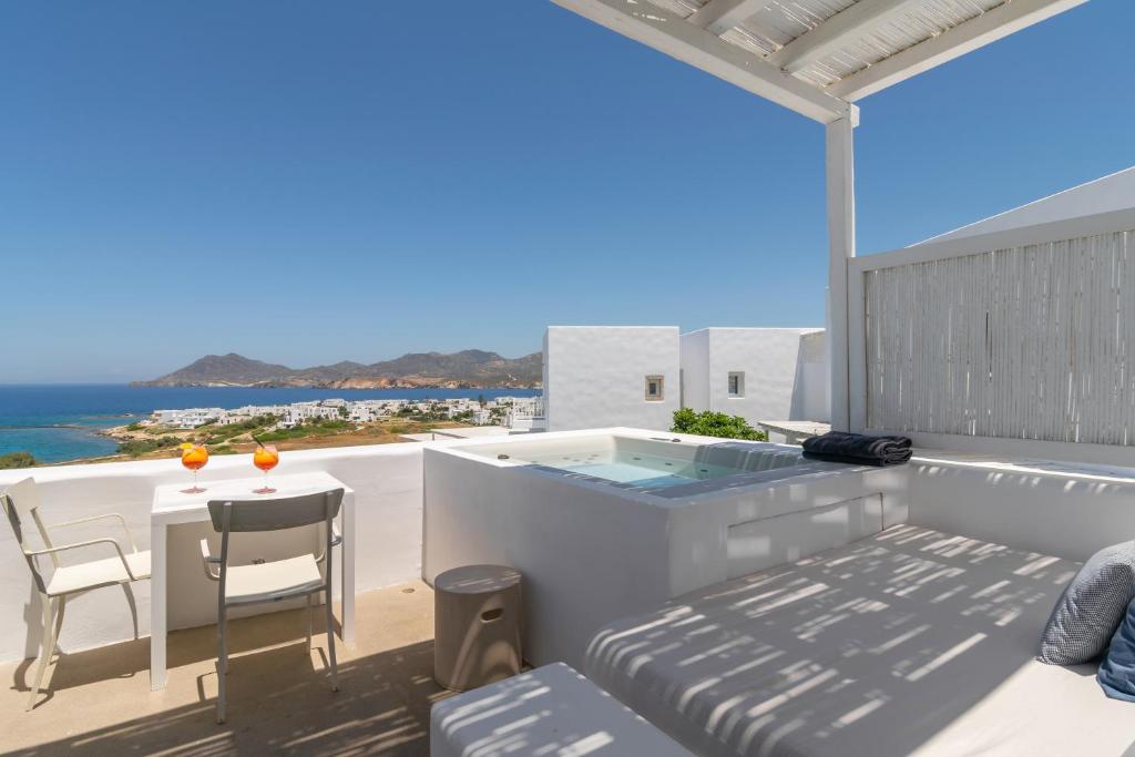 a balcony with a table and a view of the ocean at Milos Breeze Boutique Hotel in Pollonia