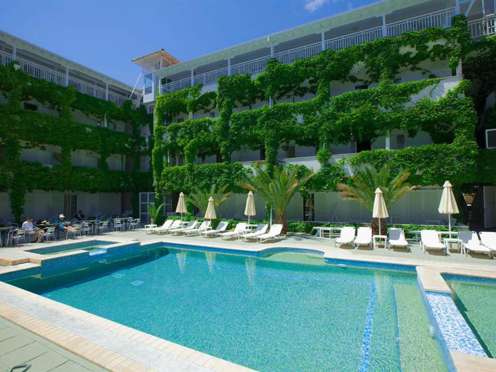 a swimming pool in front of a hotel at Olympic Kosma Hotel & Villas - Hanioti in Hanioti