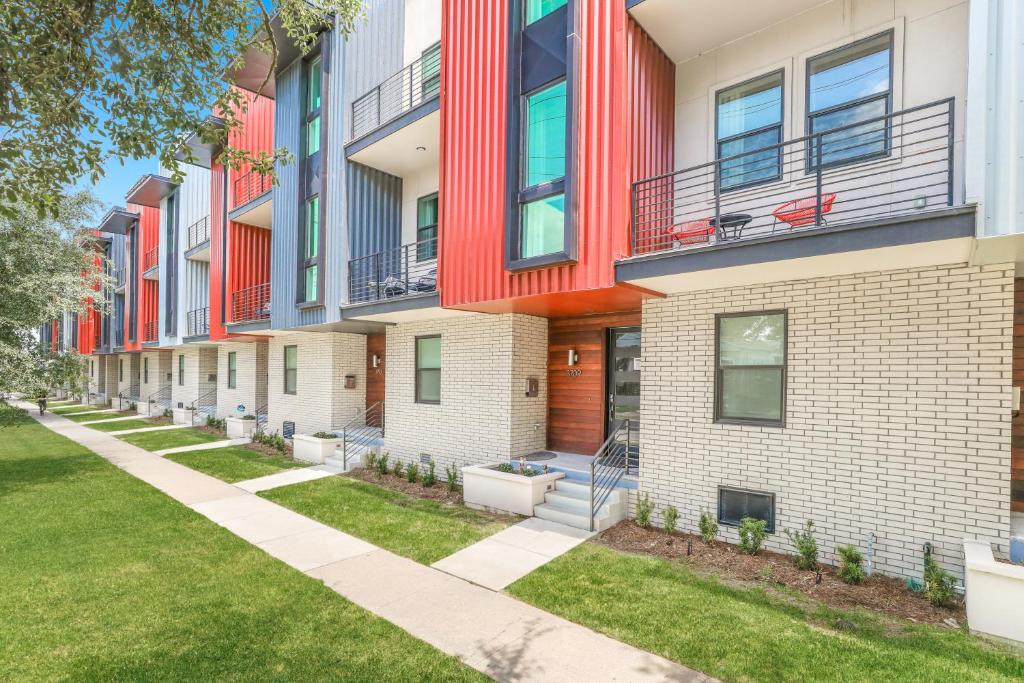 a row of apartment buildings with grass at Mid City Fully Furnished Townhouse in New Orleans