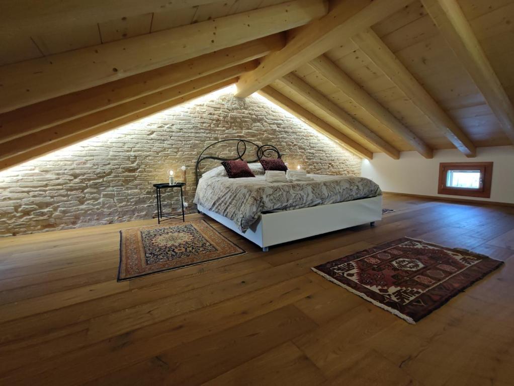 a bedroom with a bed and a brick wall at Appartamento Alla Torre 162 in Cavallino-Treporti