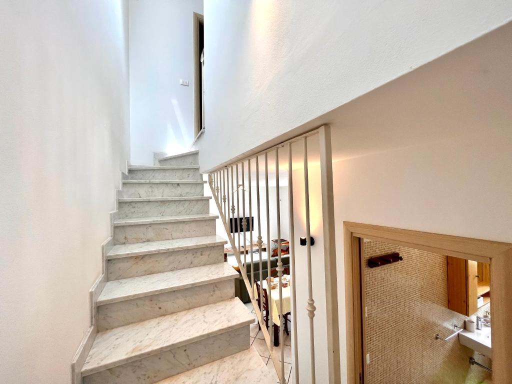 una escalera en una casa con paredes blancas en Luminoso appartamento indipendente, al mare ! en Carrara