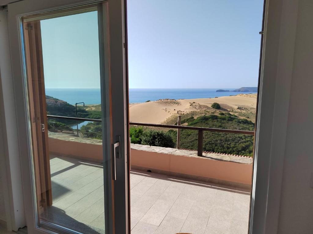 a door to a balcony with a view of the beach at Domo Allegru in Torre Dei Corsari