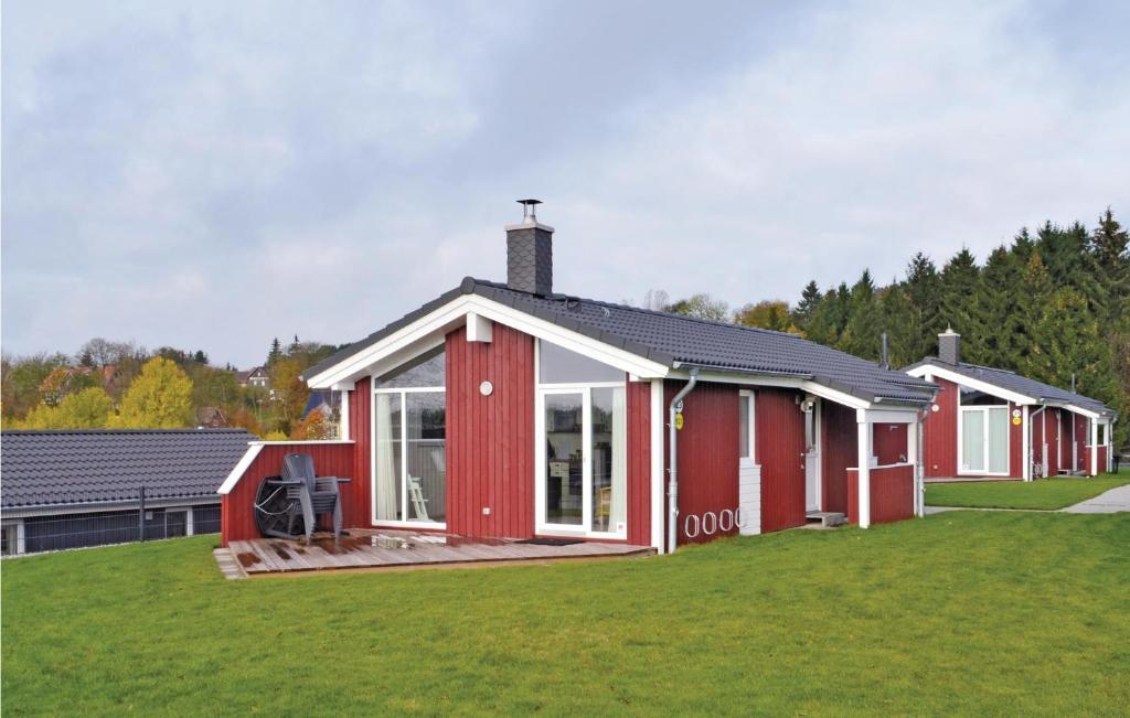ein rotweißes Gebäude auf einem Grasfeld in der Unterkunft Ferienhaus Venus C in Sankt Andreasberg