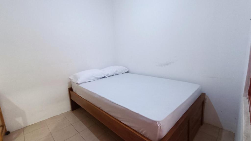 um pequeno quarto com uma pequena cama em OYO 91341 D'phoenix Anggrek Syariah Residence em Jakarta